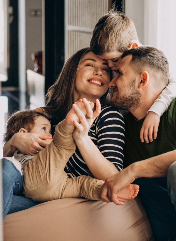 Familie mit Kindern spielt gluecklich in Eigenheim